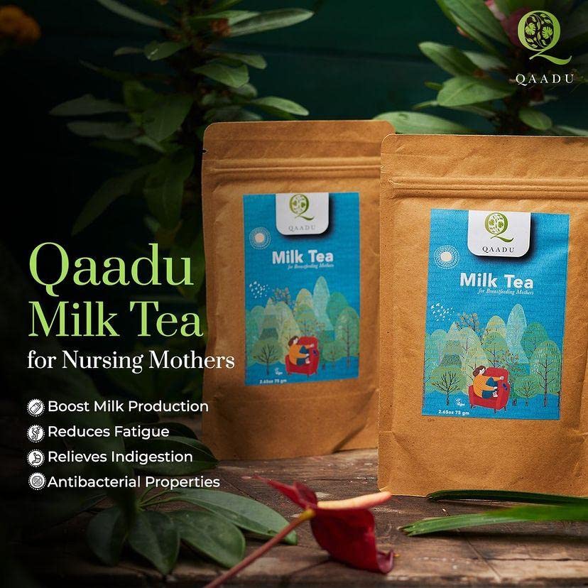 Qaadu Milk Tea for Nursing Mothers. Boost Milk Production, Reduces Fatigue, Relieves Indigestion, Antibacterial Properties. Image shows two packages of Qaadu Milk Tea on a wooden surface with green foliage in the background.